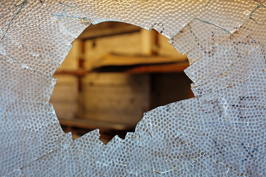 Ballard, Seattle, Washington, USA. A broken warehouse window. Looking into a derelict building., Broken glass pane
