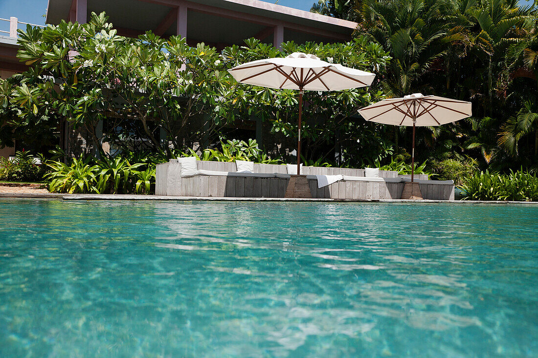 A view of the infinity swimming pool and umbrellas at Knai Bang Chatt Hotel., Kep, Cambodia. Luxury pool and umbrellas