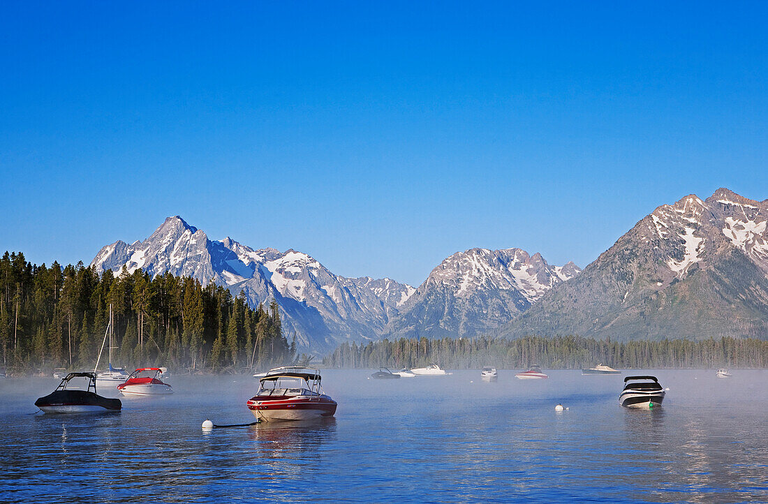 Steam rises from Jackson Lake with the Grand Tetons as background in early morning, near Leeks Marina, Grand Teton National Park, United States, Wyoming., Jackson Lake and the Grand Teton Mountains.  Grand Teton National Park, Wyoming, USA