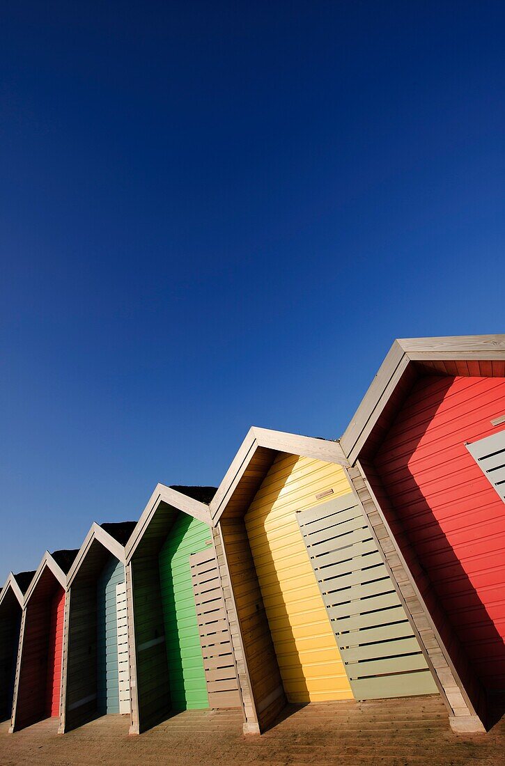 Colourful beach huts along the seafront promenade at Blyth, Northumberland, England