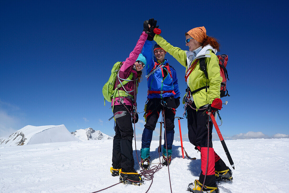 Drei Bergsteiger stehen am Gipfel des Piz Palü, Graubünden, Schweiz