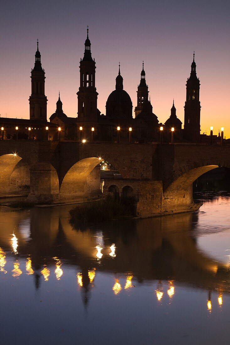 Spain, Aragon Region, Zaragoza Province, Zaragoza, Basilica de Nuestra Senora de Pilar and the Puente de Piedra bridge, on the Ebro River, dusk