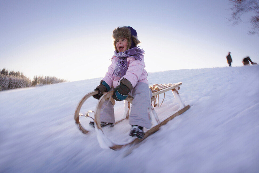 Girl sledding, Hoehenberg, Muensing, Bavaria, Germany