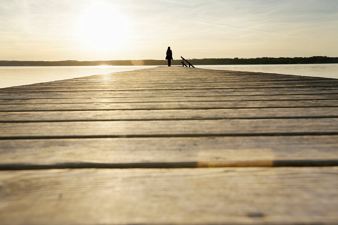 Frau steht auf einem Holzsteg am Starnberger See, Oberbayern, Bayern, Deutschland