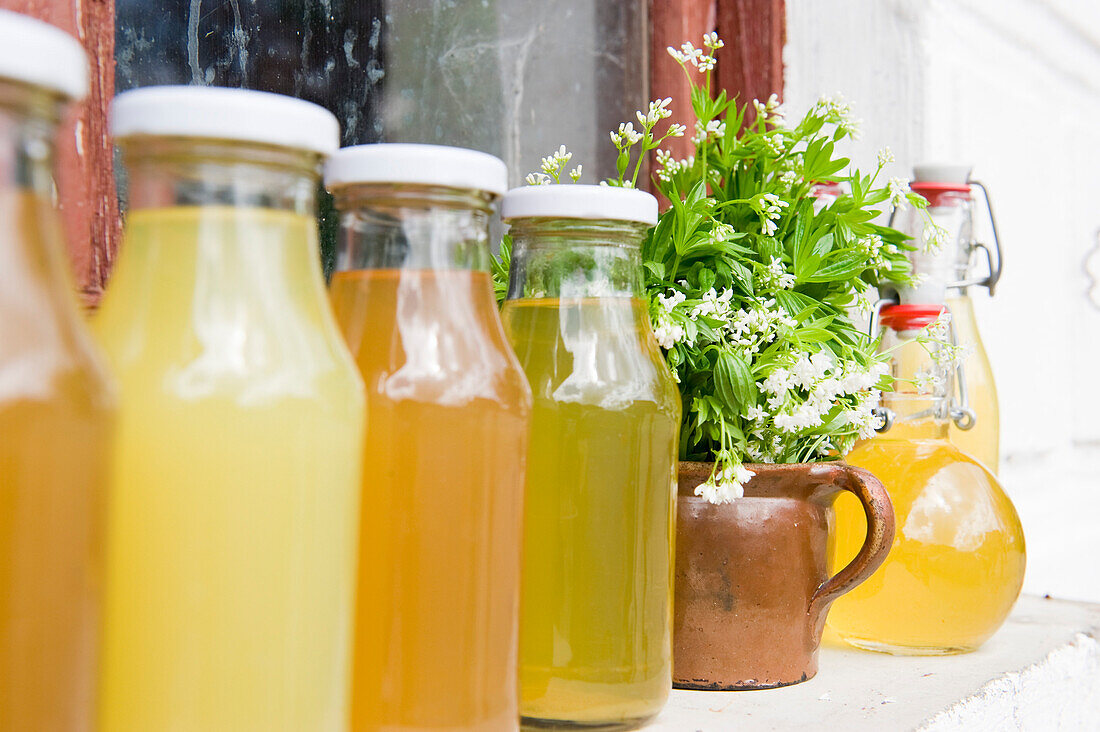 Woodruff syrup, juice and liqueur on a window sill, homemade