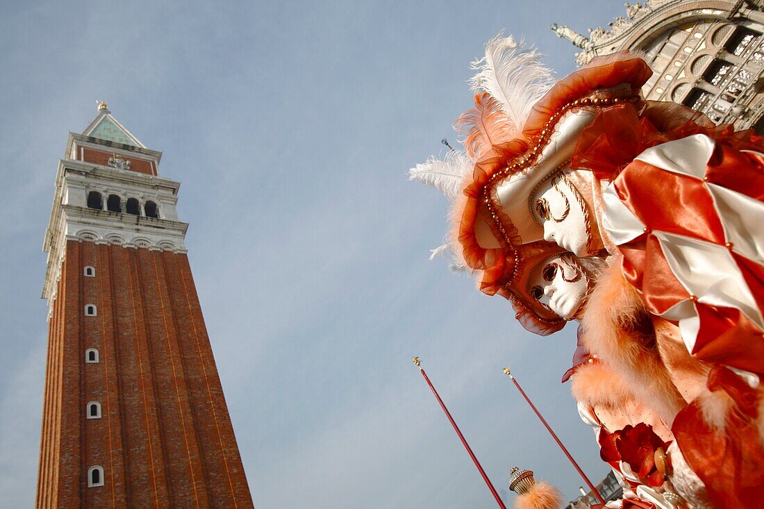 Venetian masks at Venice Carnival 2009, with St Mark´s bell tower, Venice, Italy