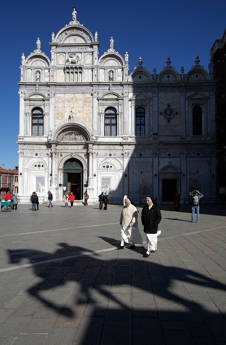 Couple of Nuns in Campo San Giovanni e Paolo with the shade of Colleoni equestrian monument, Venice, Italy