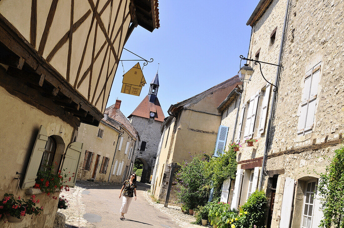 Frau spaziert durch das Dorf Charroux, Sioule Tal, Bourbonnais, Auvergne, Frankreich, Europa