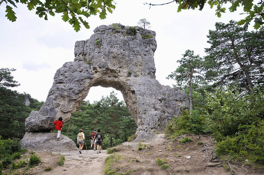 Hikers in front of a rock arch, Chaos de Montpellier le Vieux, Cevennen, Languedoc, France, Europe