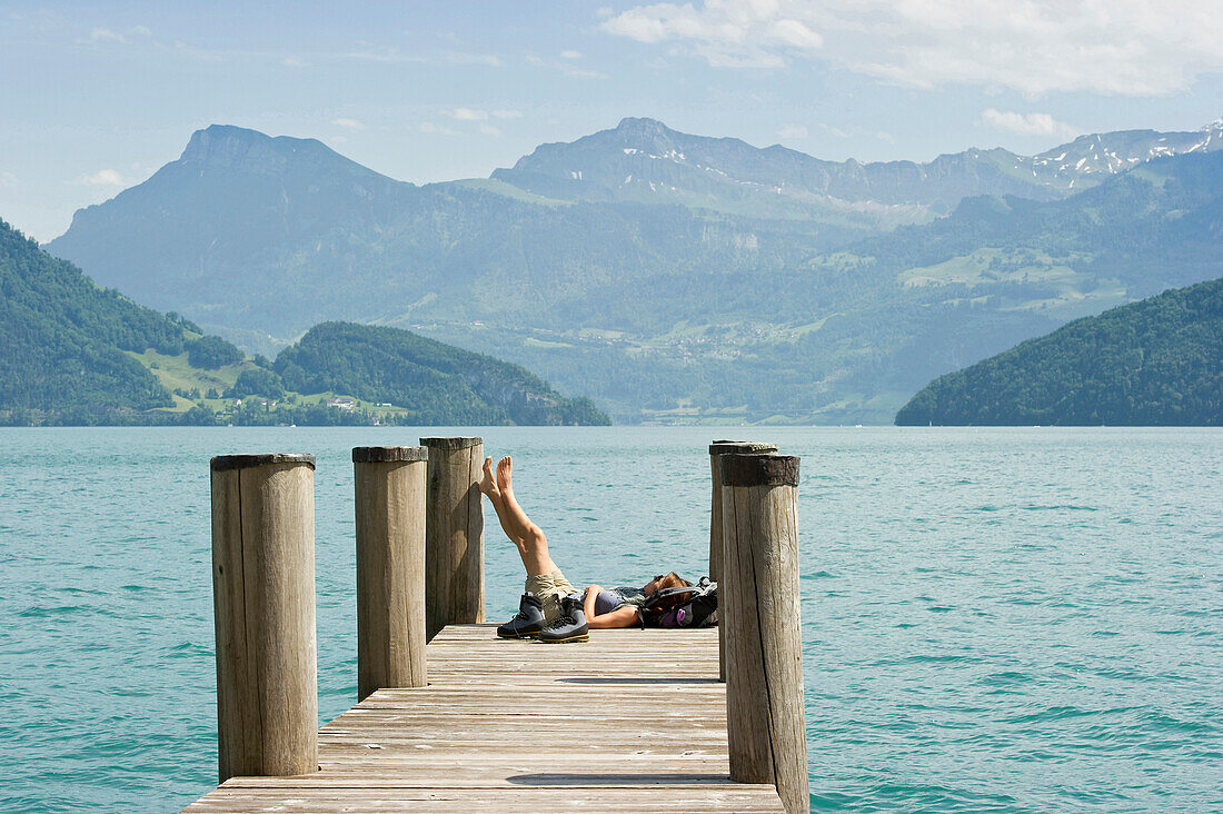 Female hiker sitting on a landing stage in Weggis, Lake Lucerne, canton Lucerne, Switzerland, Europe