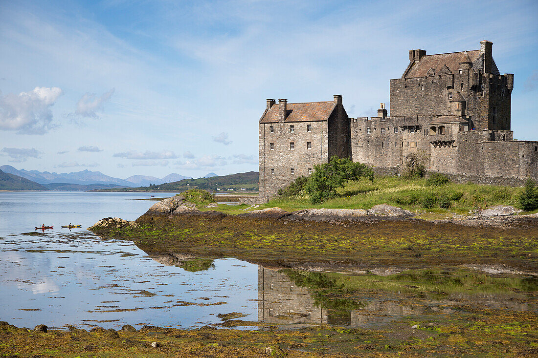 Zwei Kajakpaddler vor Burg Eilean Donan Castle am Ufer von Loch Duich, nahe Dornie, Highland, Schottland, Großbritannien, Europa