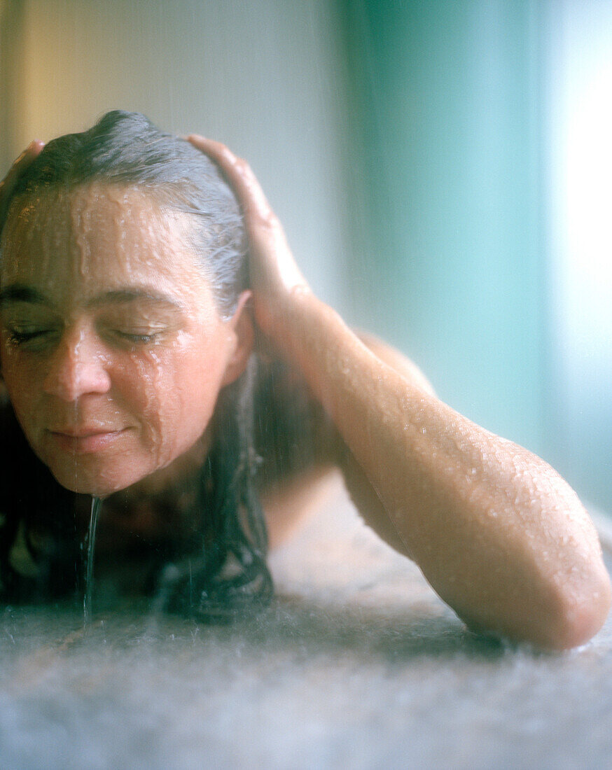 Frau unter einer Regendusche in einem Spa, Hotel Loisium Wine Spa Resort, Langenlois, Niederösterreich, Österreich