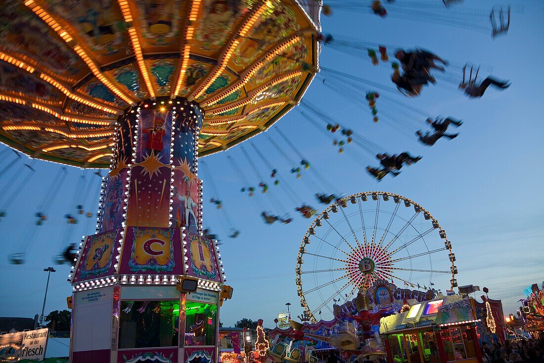 parish fair with chairoplane and Ferris wheel at night, Luxembourg