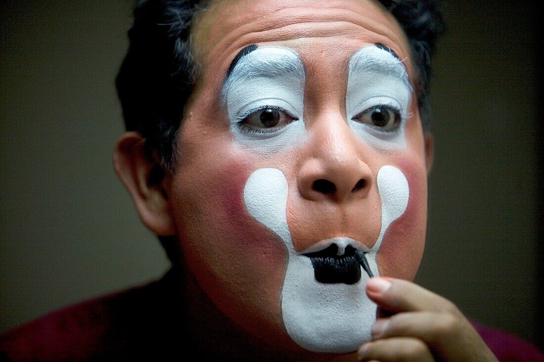 A clown puts on his make-up in front of a mirror in his hotel room before attending the 16th International Clown Convention: The Laughter Fair organized by the Latino Clown Brotherhood, in Mexico City, October 17, 2011