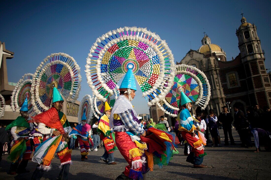 Dancers from Huehuetla, Puebla state, perform the Quetzal dance outside the Our Lady of Guadalupe Basilica in Mexico City, December 10, 2011  Hundreds of thousands of Mexican pilgrims converged on the Basilica, bringing images to be blessed, as procession