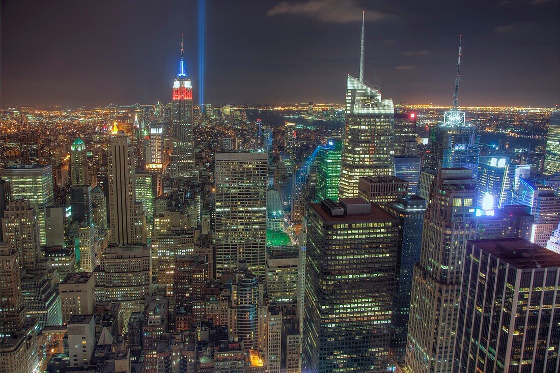 The twin beams of light of the Tribute in Light, a memorial to the events of September 11, 2001, shine into the evening sky behind the Empire State Building, Bank of America Building, Conde Nast Building, and other Manhattan skyscrapers, New York City. Th