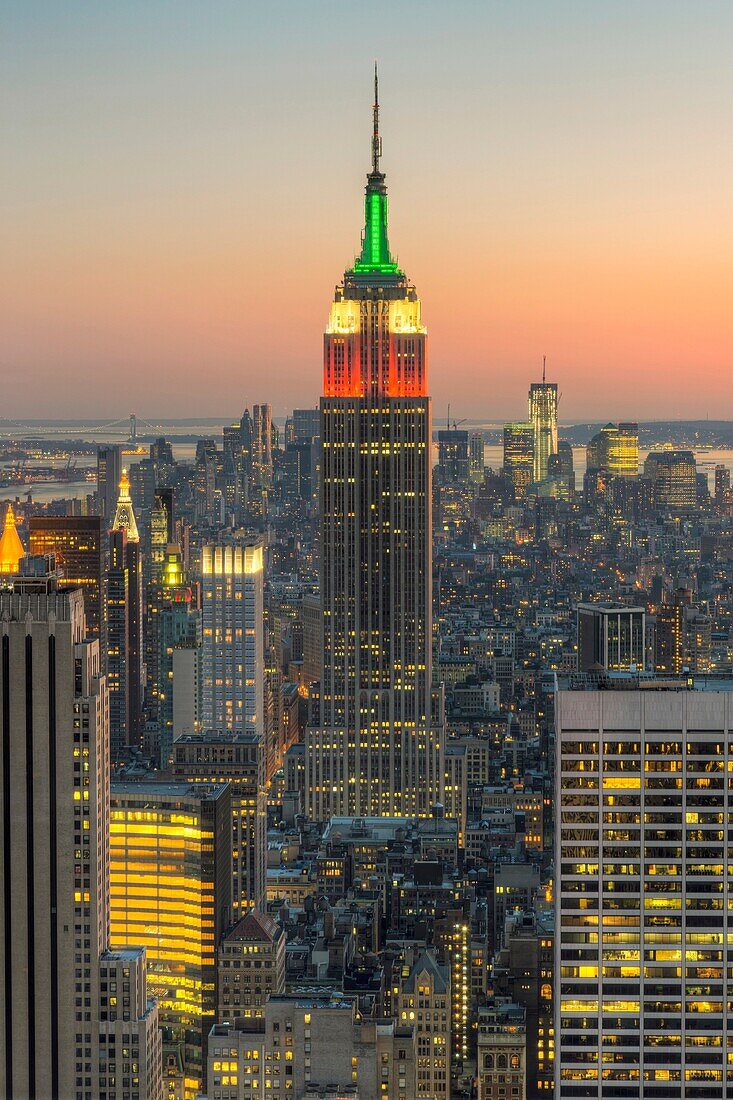 View looking south at twilight from the Top of the Rock including the Empire State Building, illuminated in Red/White/Green in honor of Columbus Day, and other Manhattan skyscrapers. View looking south at twilight from the Top of the Rock including the Em