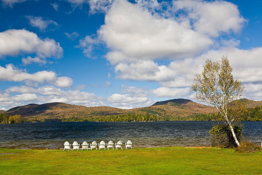 White chairs on shore of Blue Mountain Lake in the Adirondack Mountains of New York