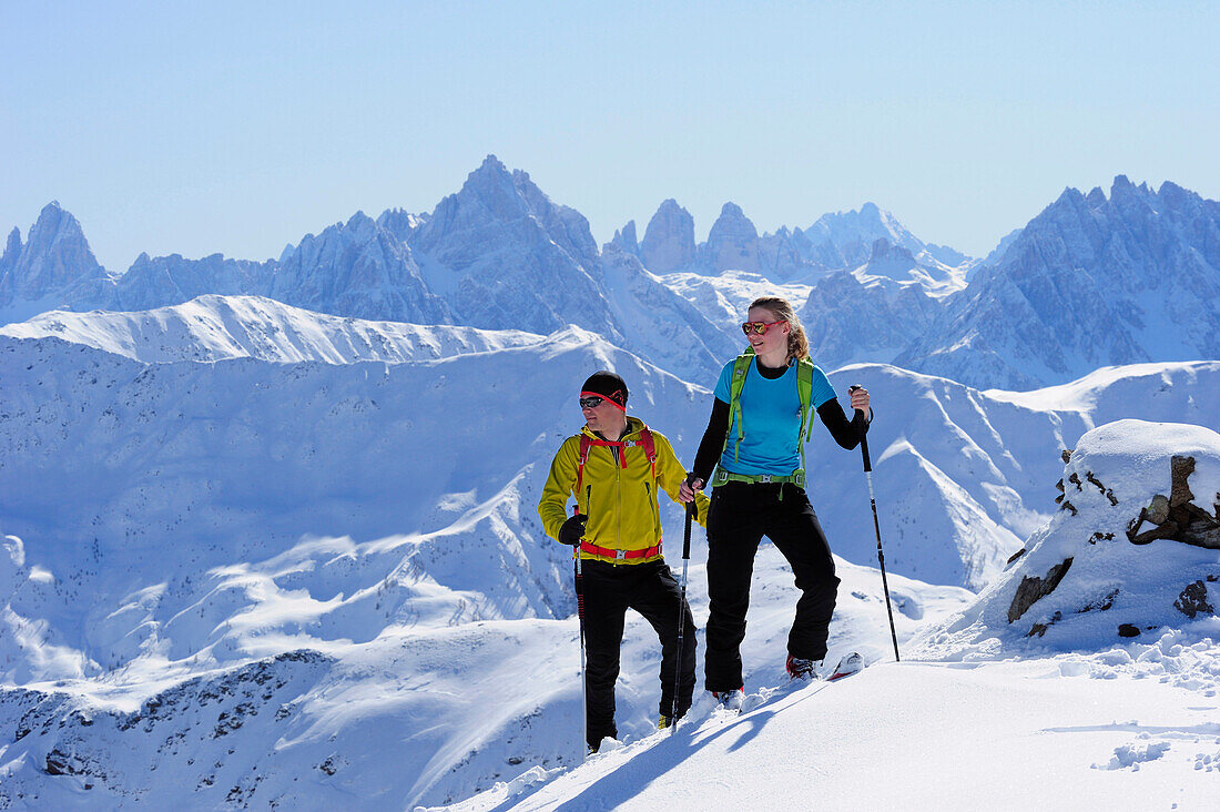 Two cross-country skiers ascending to mount Kreuzspitze, Dolomites with Tre Cime di Lavaredo in background, East Tyrol, Tyrol, Austria