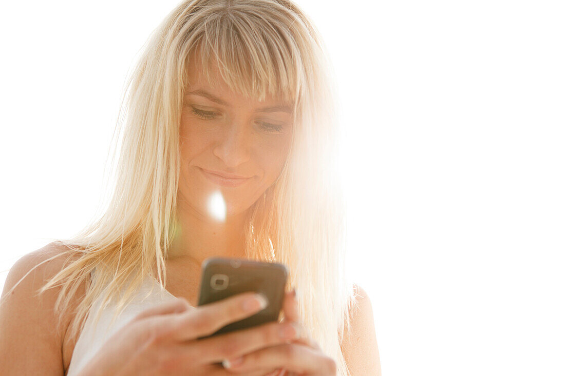 Young woman holding a mobile phone, Munich, Bavaria, Germany