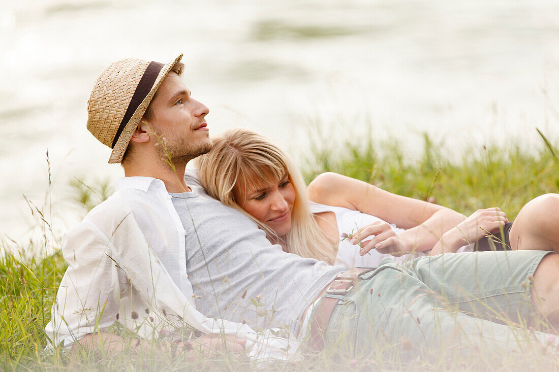 Young couple on the Isar riverbank, Munich, Bavaria, Germany