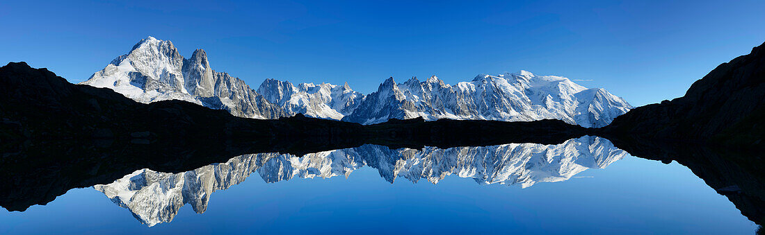 Panorama of Mont Blanc range reflecting in a mountain lake, Mont Blanc range, Chamonix, Savoy, France