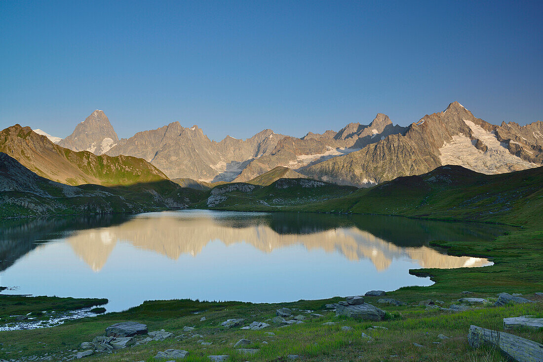 Mont Blanc range with Grandes Jorasses and Mont Dolent reflecting in a mountain lake, Pennine Alps, Aosta valley, Italy