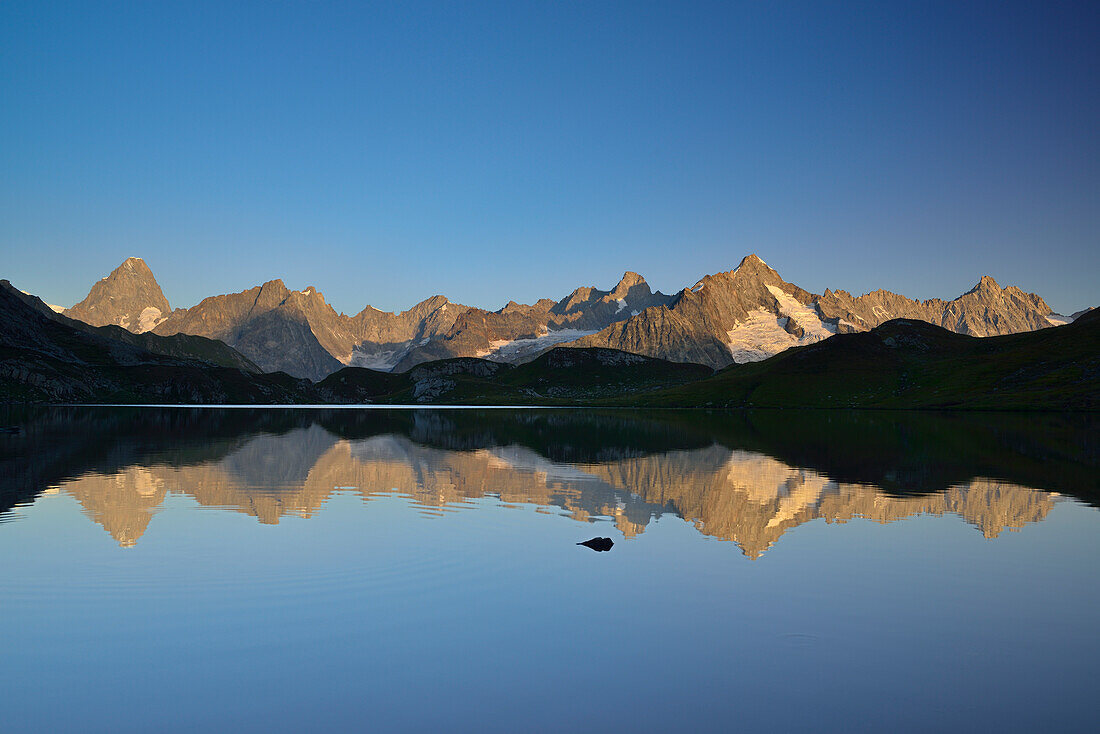Mont Blanc range with Grandes Jorasses and Mont Dolent reflecting in mountain lake, Pennine Alps, Aosta valley, Italy