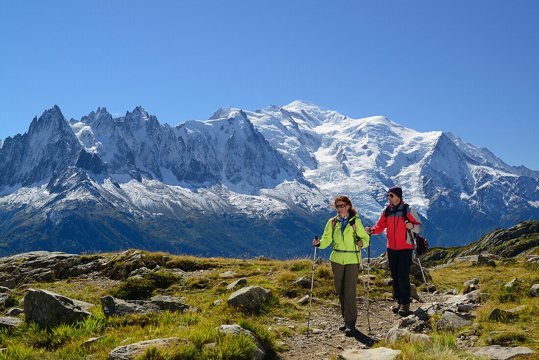 Frau und Mann beim Wandern mit Blick auf Aiguilles du Chamonix, Aiguille du Midi und Mont Blanc, Montblanc-Gruppe, Mont Blanc, Chamonix, Savoyen, Frankreich
