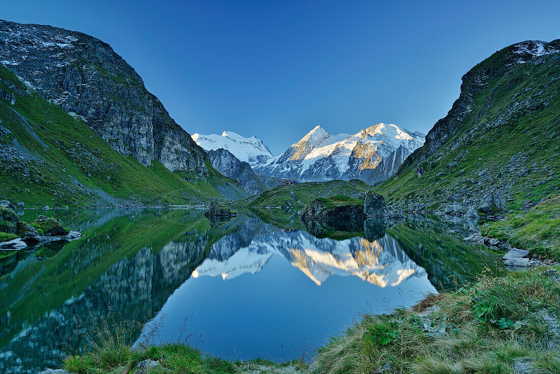 Grand Combin, Combin de Corbassiere and Petit Combin reflecting in a mountain lake, Pennine Alps, Valais, Switzerland