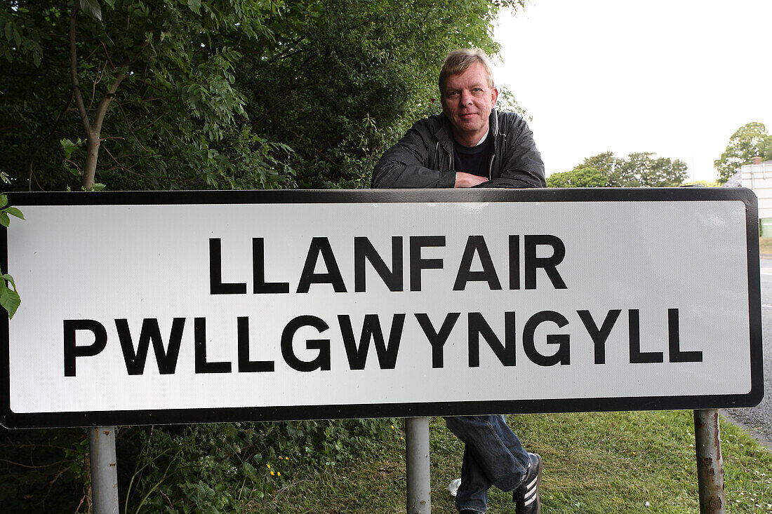 Ortsschild von Llanfair Pwllgwyngyll und Fotograf Tilman Schuppius, Nord Wales, Großbritannien, Europa