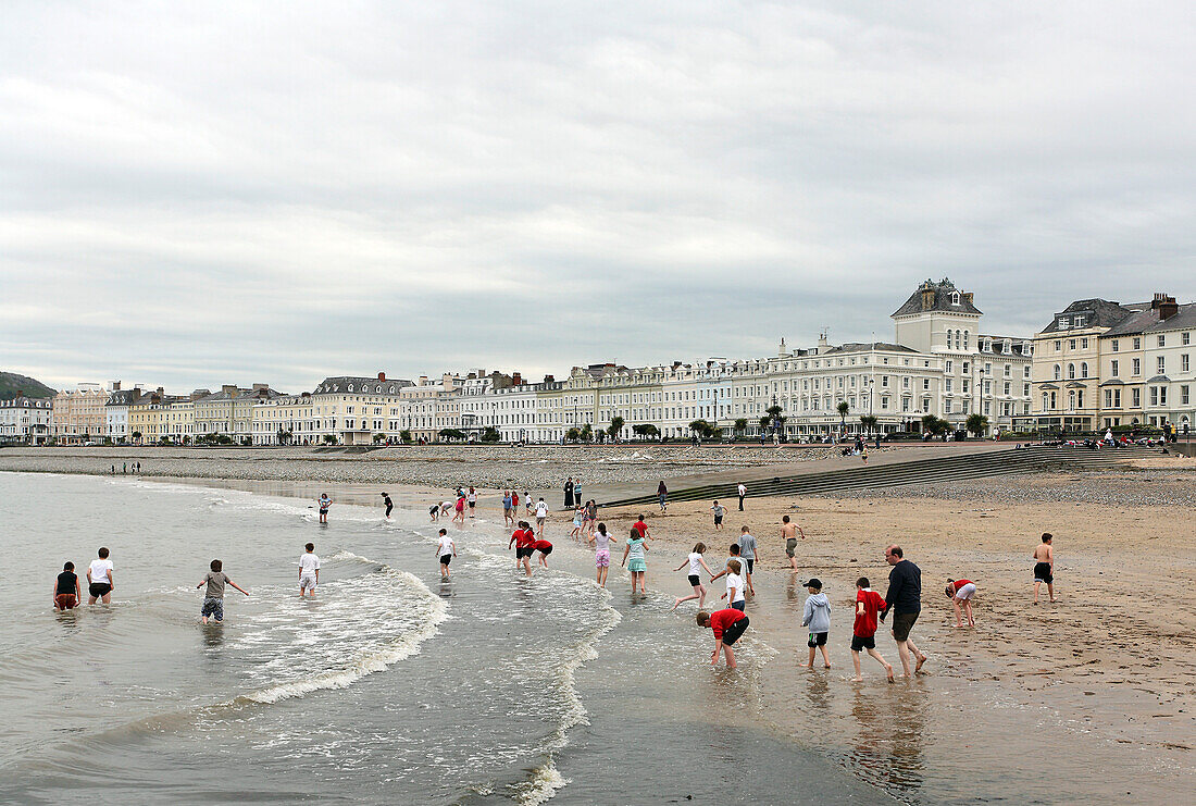 Menschen am Strand des Seebads Llandudno, Nord Wales, Großbritannien, Europa