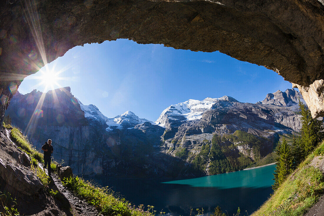 Ein Mann beim Wandern am Norduferweg, Blick zum Doldenhorn, Fründenhorn, Oeschinenhorn, Blüemlisalp-Rothorn, Oeschinensee, Berner Oberland, Kanton Bern, Schweiz