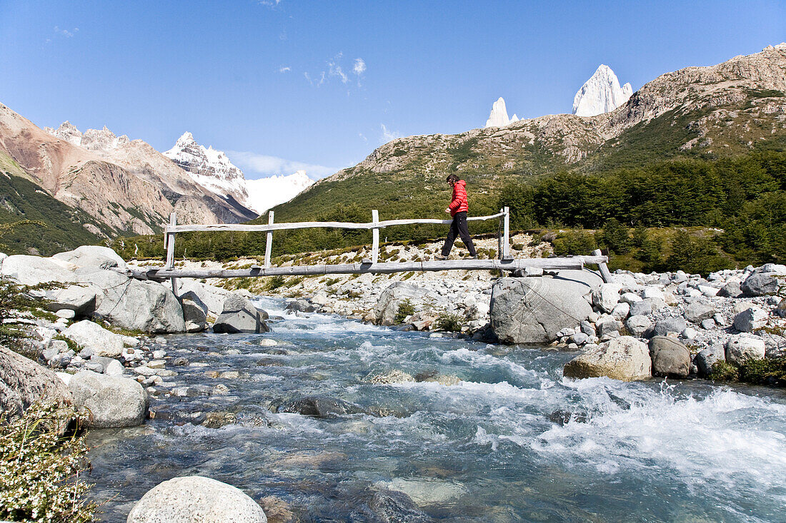 Man crossing a wooden bridge above a glacial stream, Fitz Roy, El Chalten, Patagonia, Argentina