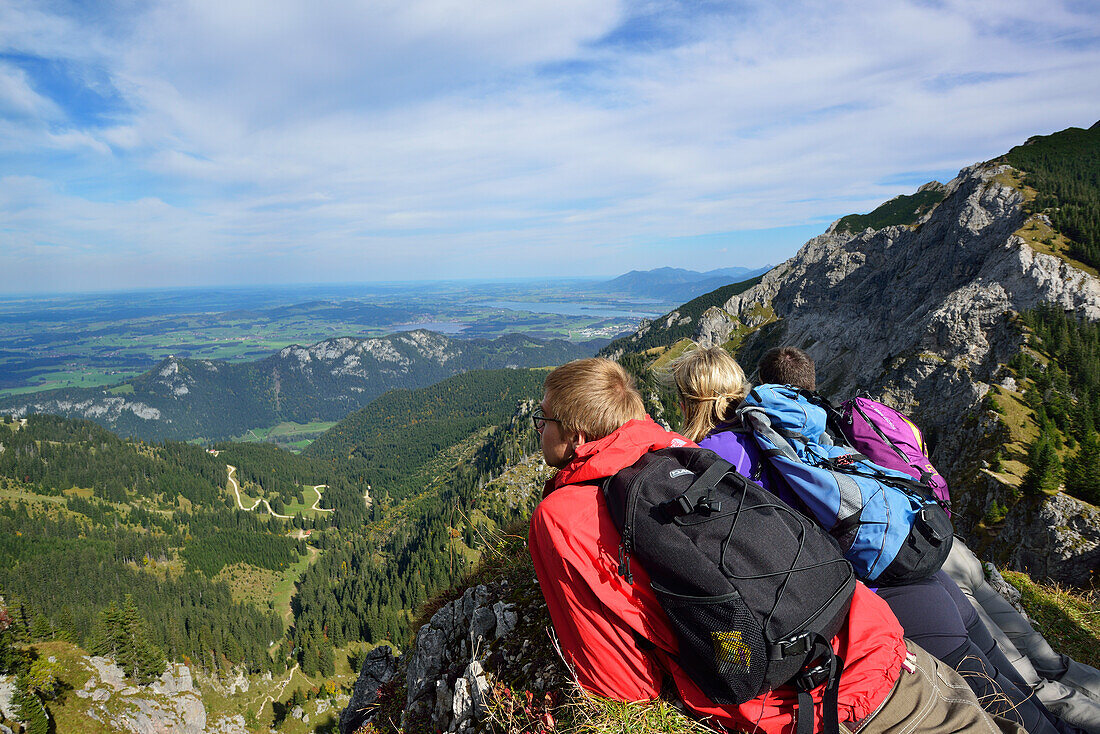 Young woman and two young men enjoying the view from Aggenstein to Fuessen, Aggenstein, Tannheim range, Tyrol, Austria