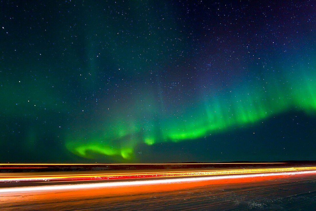 Aurora Borealis Northern Polar Lights with truckers lights on the ice road outside Yellowknife, Northwest Territories, Canada