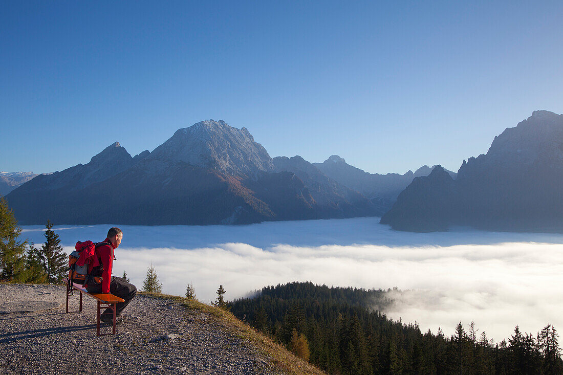 Wanderer blickt über den Nebel im Tal auf Watzmann und Hochkalter, Berchtesgadener Land, Nationalpark Berchtesgaden, Oberbayern, Bayern, Deutschland, Europa