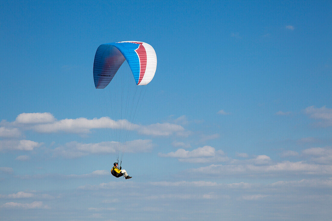 Gleitschirmflieger, Paraglider vor Wolkenhimmel