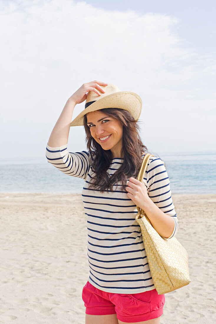 Portrait of a young brunette woman arriving at the beach