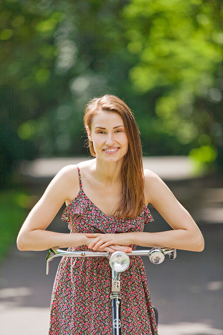 Pretty woman with bicycle in the park