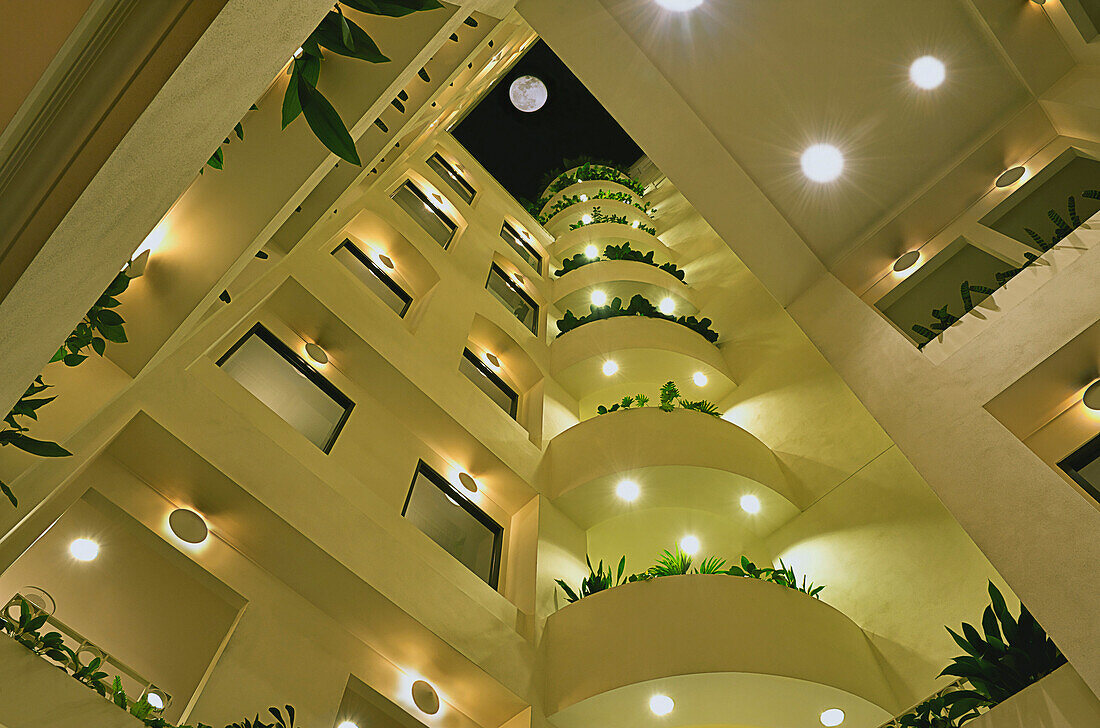The courtyard of the Lucia Hotel. A central atrium or lobby, with a view to the sky. A full moon.