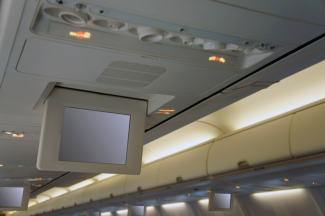 Drop down screens on an aircraft. Television and information monitors for passengers. Inflight entertainment.