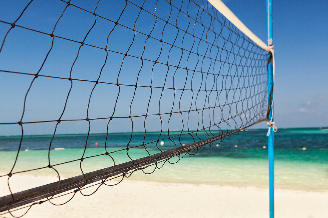 Volleyball net on beach at Cancun. Sea shore, coastline, net and post. Game court.