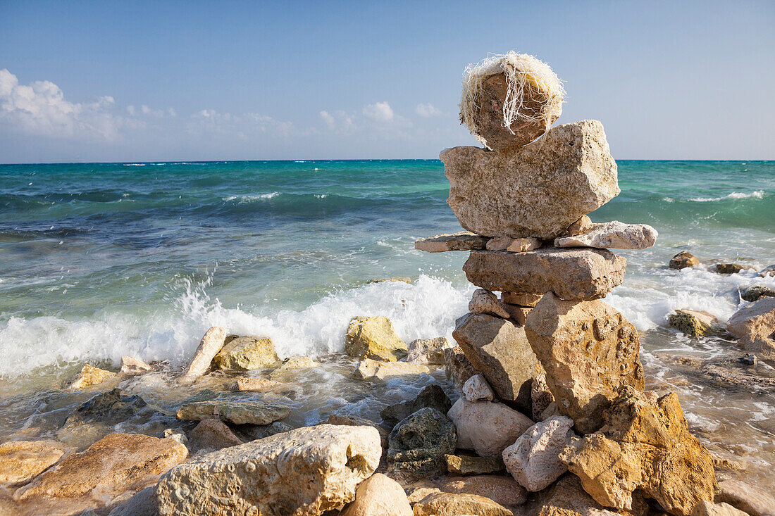 Stacked rock figure on the beach at Playa del Carmen. A cairn, pile of stones on the shore.