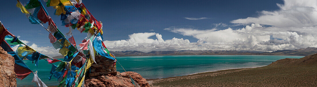 View of freshwater Lake Manasarovar from Chiu Gompa or Monastery . Buddhist sacred lake. Prayer flags fluttering in the wind.