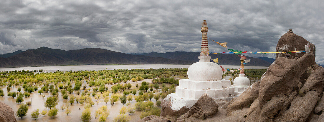 Stupas and small shrines near the Yarlung river. Buddhist prayer flags. Mountain landscape.