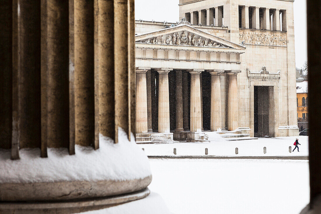 snow-covered Königsplatz, girl walking in front of Propyläen, view from Antikensammlung, Munich, Bavaria, Germany