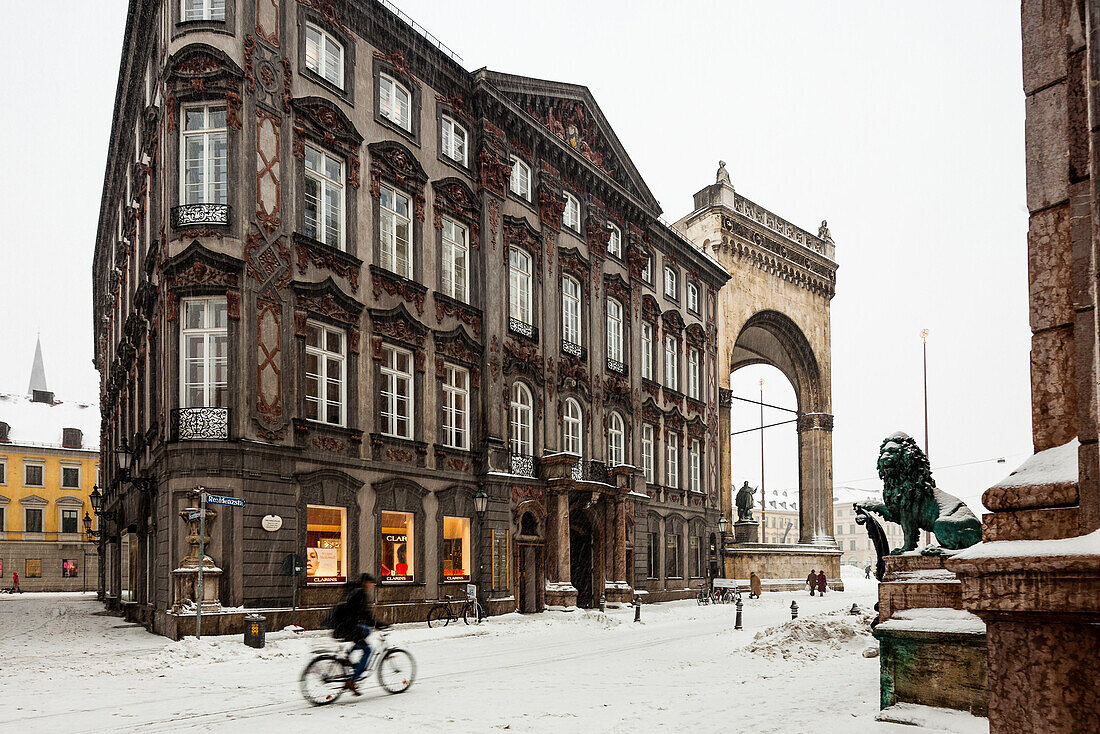 Feldherrnhalle, Odeonsplatz and lion statue, bicyclist at night in snow drift, Munich, Bavaria, Germany