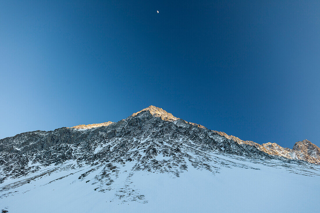 Lisenser Fernerkogl in winter at sunset with half moon, view from Laengental valley, Sellrain, Innsbruck, Tyrol, Austria