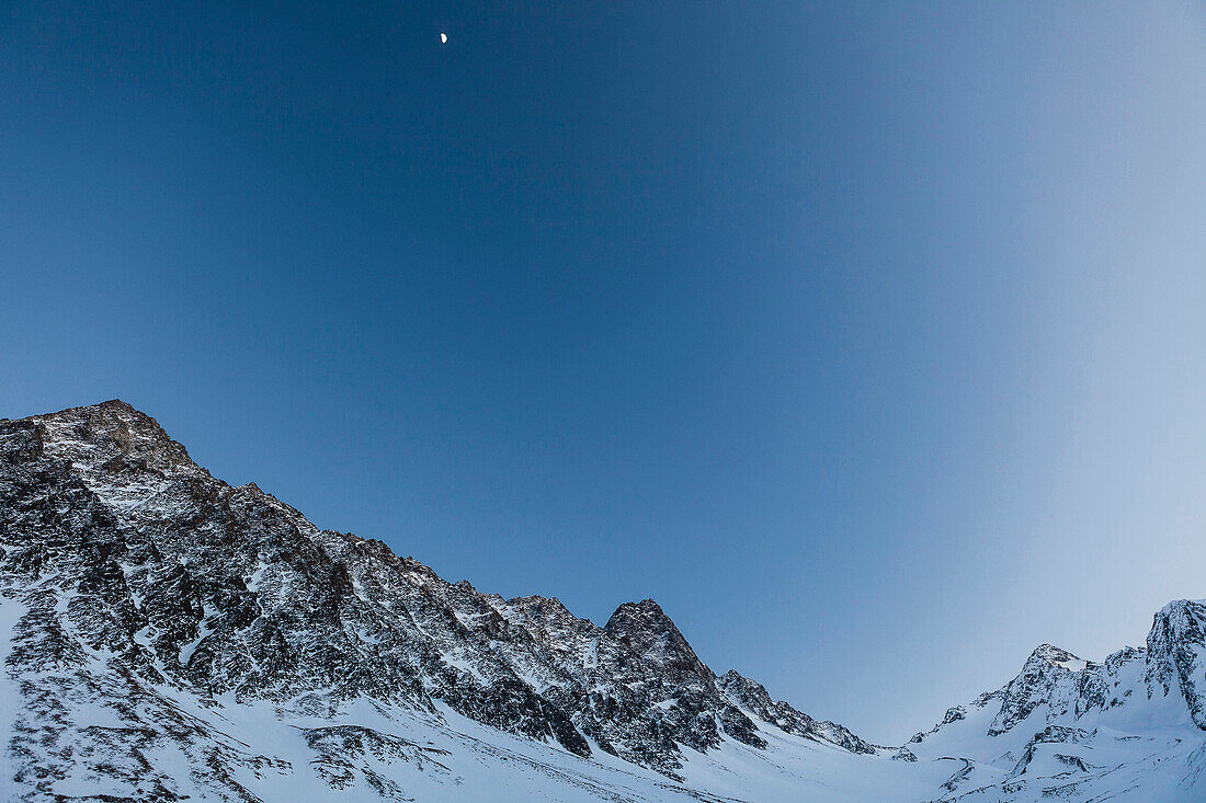 Lisenser Fernerkogl, Brunnenkogl and Bachfallenkopf in winter with half moon at dusk, view from Laengental valley, Sellrain, Innsbruck, Tyrol, Austria